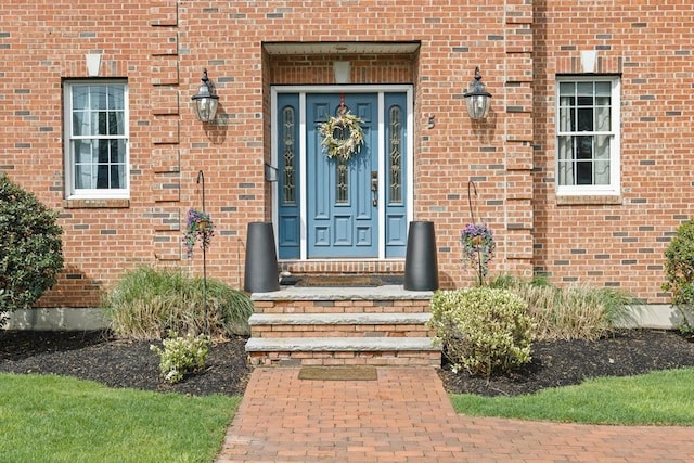 entrance to property featuring brick siding