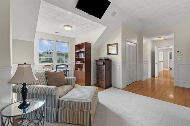 living area featuring wood finished floors and a wainscoted wall