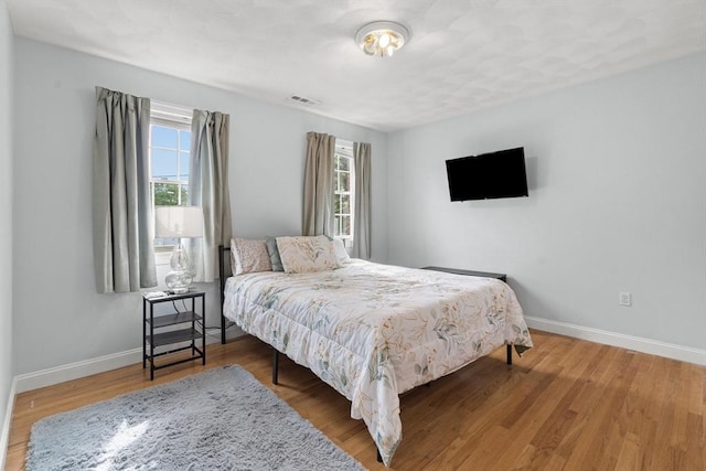 bedroom featuring baseboards and wood finished floors