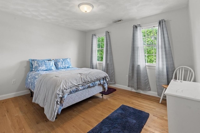 bedroom with baseboards and light wood-style flooring