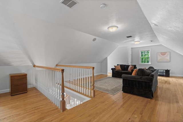 bonus room with lofted ceiling, wood finished floors, and baseboards
