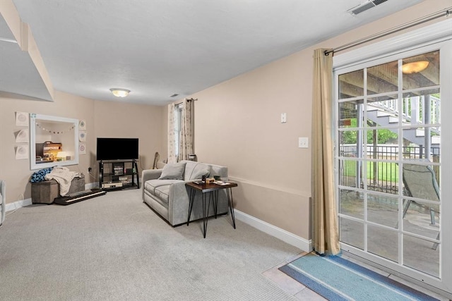 living area with light colored carpet and baseboards