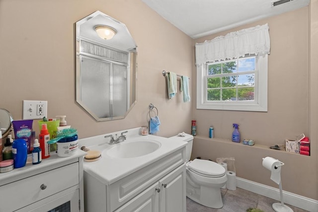 bathroom featuring a shower with shower door, vanity, tile patterned floors, and toilet