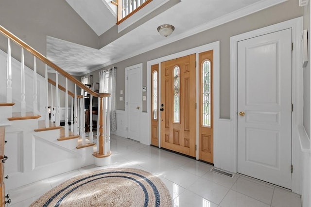 tiled foyer featuring stairway and ornamental molding