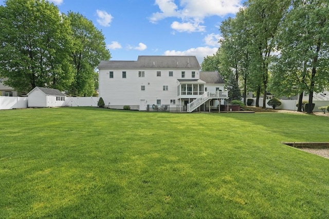 back of property with a sunroom, a storage unit, stairway, and an outdoor structure