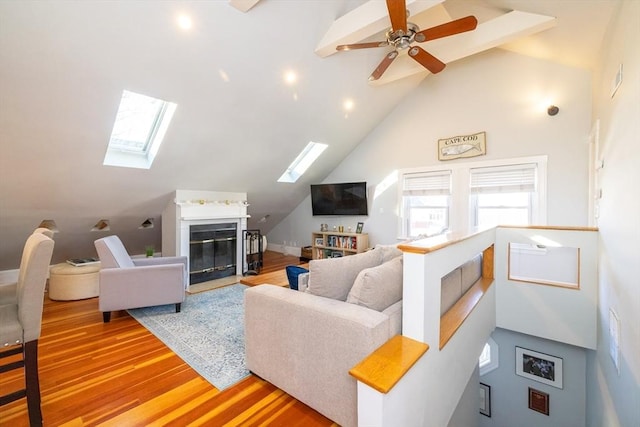 345 Ashmont St Unit 3, Boston, MA 02124 - living area with ceiling fan, lofted ceiling with skylight, a fireplace with flush hearth, and light wood-style floors