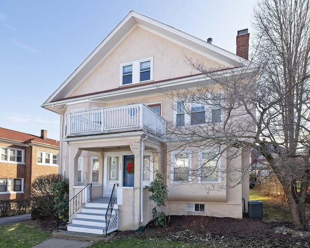 345 Ashmont St Unit 3, Boston, MA 02124 - view of front of property featuring central AC, stucco siding, a chimney, a balcony, and a porch