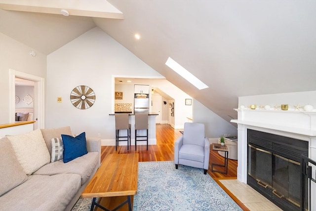 345 Ashmont St Unit 3, Boston, MA 02124 - living room with light wood-type flooring, recessed lighting, lofted ceiling with skylight, baseboards, and a fireplace with flush hearth