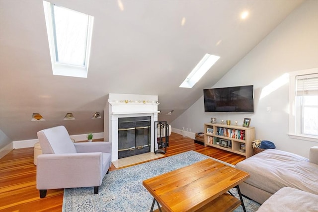 345 Ashmont St Unit 3, Boston, MA 02124 - living room with baseboards, lofted ceiling with skylight, a glass covered fireplace, and wood finished floors
