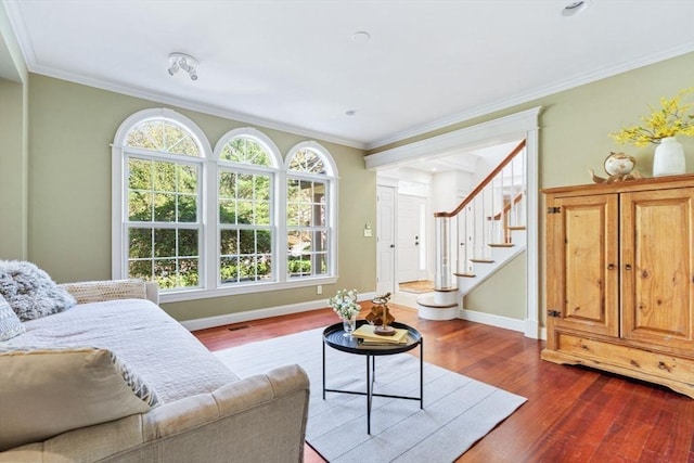 living room with dark wood finished floors, baseboards, stairway, and ornamental molding
