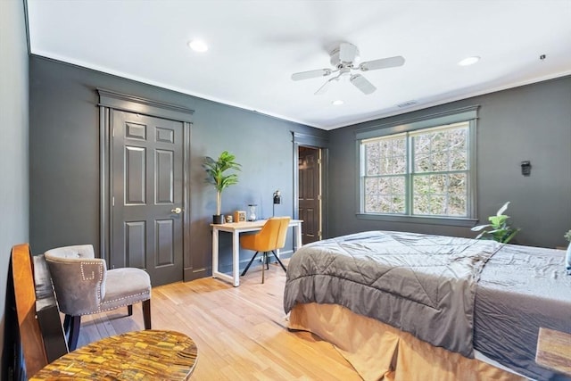 bedroom featuring light wood-type flooring, recessed lighting, a ceiling fan, and ornamental molding