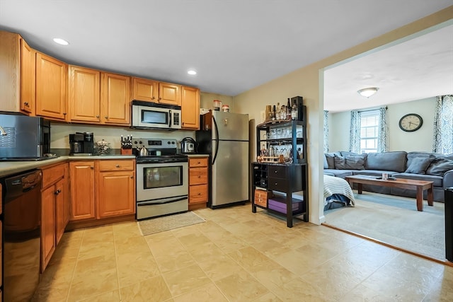 kitchen featuring light carpet and black appliances