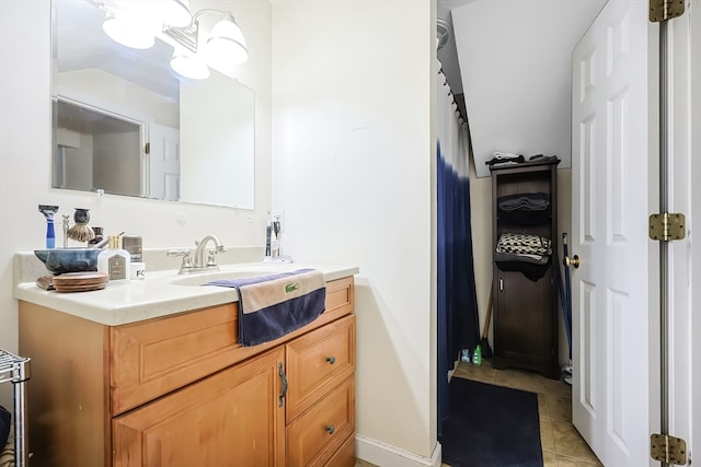 bathroom with a notable chandelier, vanity, and tile patterned flooring