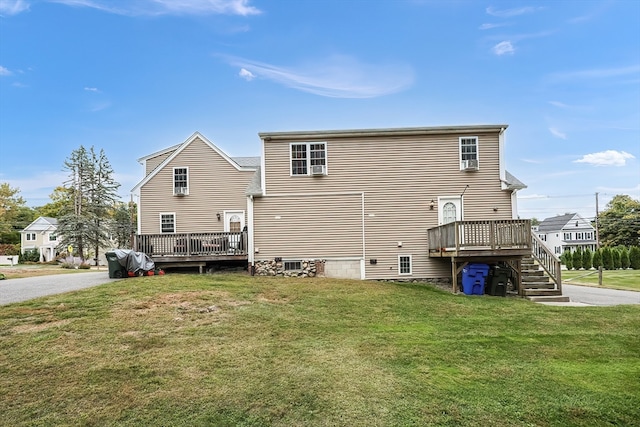 back of house featuring a lawn and a deck