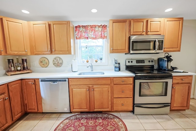 kitchen featuring stainless steel appliances, light tile patterned floors, and sink