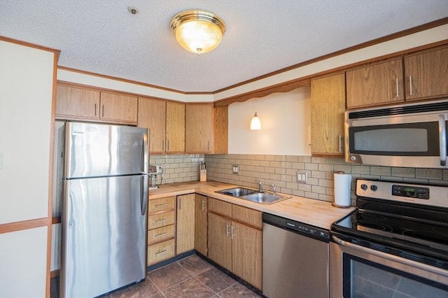 kitchen featuring crown molding, appliances with stainless steel finishes, tasteful backsplash, and a sink