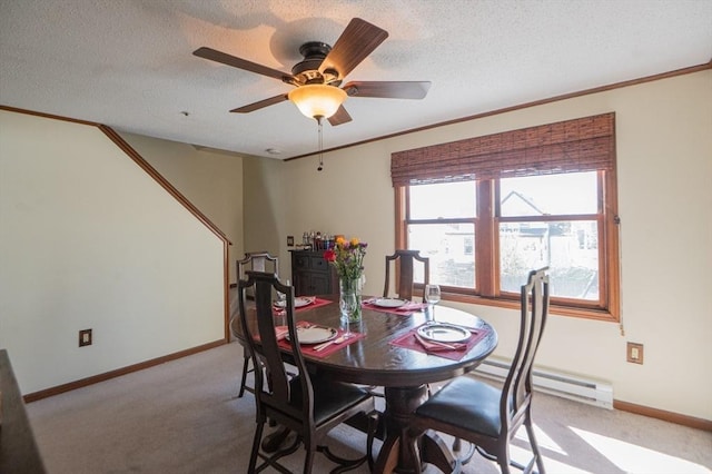 dining area featuring light colored carpet, crown molding, baseboards, and ceiling fan