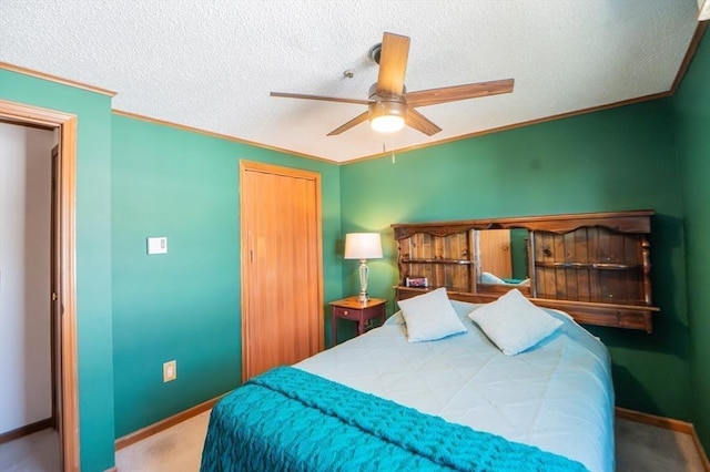 carpeted bedroom featuring a closet, a textured ceiling, ceiling fan, crown molding, and baseboards