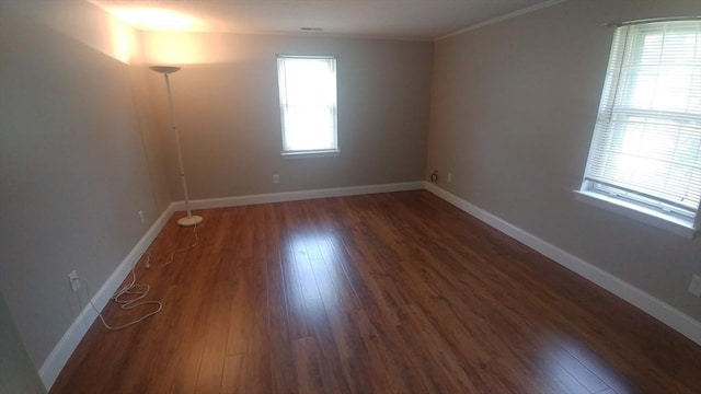 empty room with dark hardwood / wood-style flooring and ornamental molding