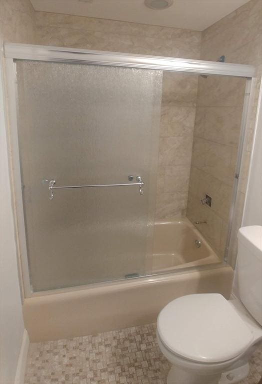 bathroom with enclosed tub / shower combo and toilet