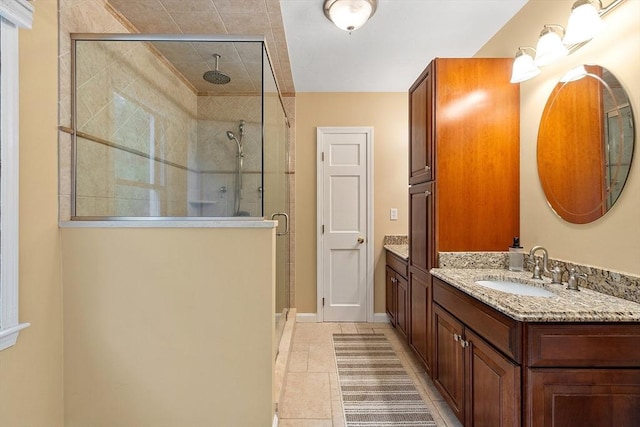 bathroom featuring a stall shower, vanity, tile patterned flooring, and baseboards