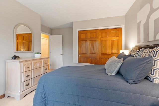 bedroom featuring light carpet and baseboards