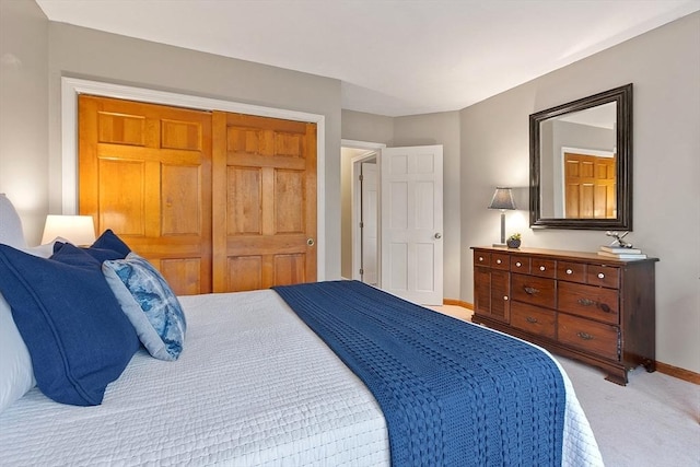 bedroom with light colored carpet and baseboards