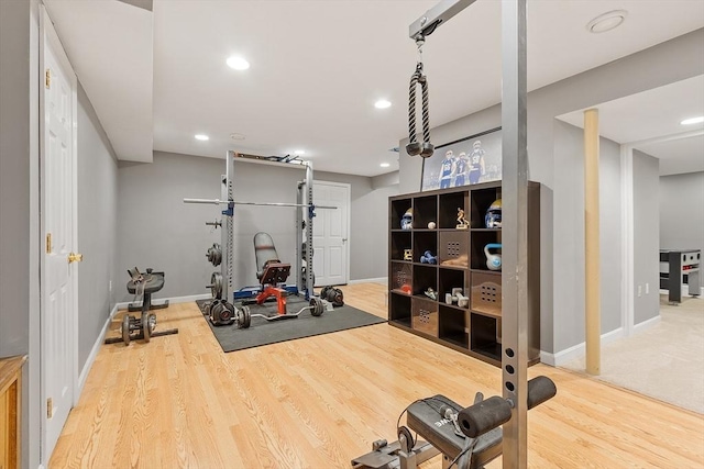 exercise area featuring wood finished floors, baseboards, and recessed lighting
