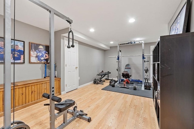 workout room featuring wood finished floors, recessed lighting, and baseboards