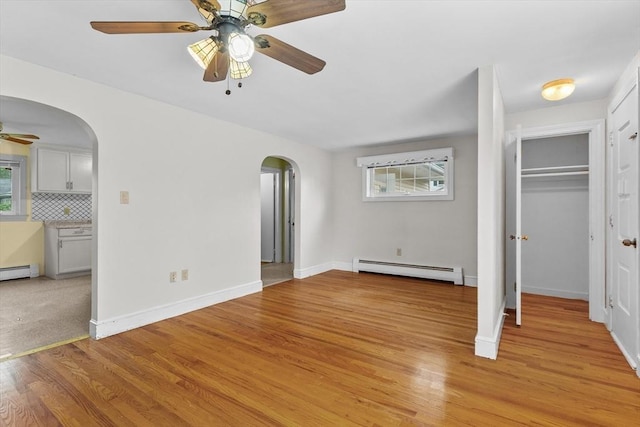 7 Burgess St, Methuen, MA 01844 - unfurnished bedroom featuring arched walkways, a baseboard radiator, light wood-style flooring, and a closet