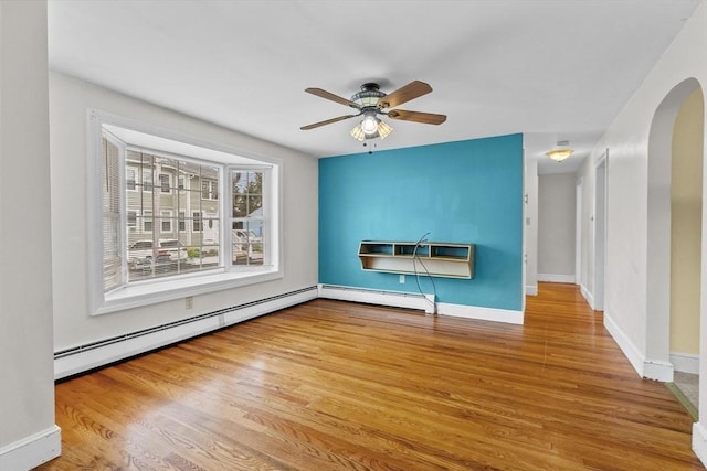 7 Burgess St, Methuen, MA 01844 - unfurnished living room featuring an AC wall unit, wood finished floors, a ceiling fan, a baseboard heating unit, and arched walkways