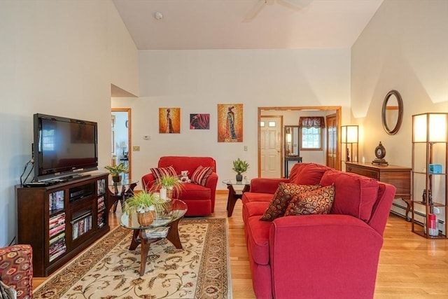 7 Chandler Way Unit 7, Northborough, MA 01532 - living room featuring light wood-style flooring, ceiling fan, a baseboard heating unit, and a towering ceiling