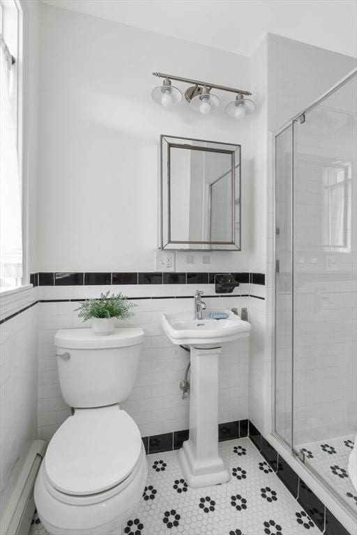 39 Calvin St Unit 3, Somerville, MA 02143 - bathroom featuring baseboard heating, a stall shower, tile patterned floors, a wainscoted wall, and tile walls