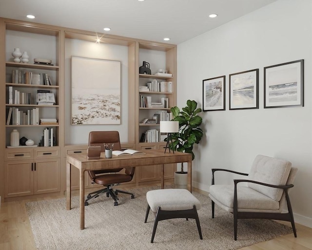 office with baseboards, built in shelves, recessed lighting, and light wood-style floors