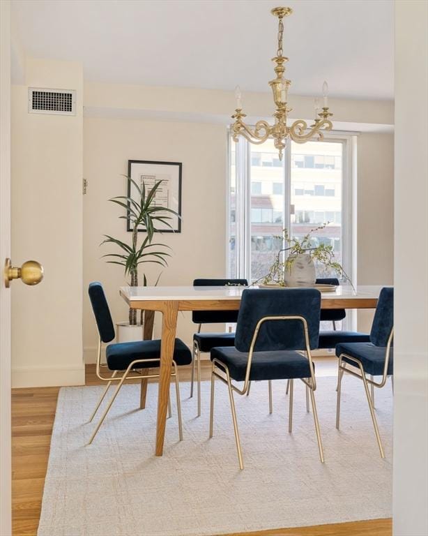 dining space with a notable chandelier and wood-type flooring