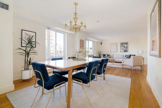 dining area featuring a chandelier and light hardwood / wood-style floors