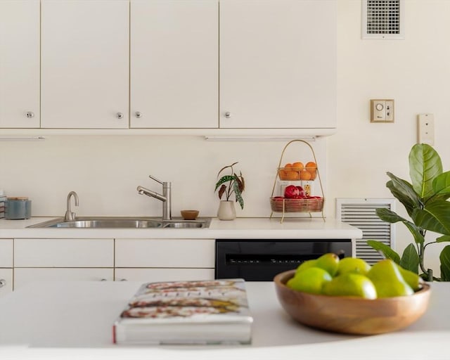 kitchen featuring dishwasher, white cabinetry, and sink