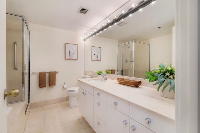 bathroom featuring tile patterned flooring, vanity, toilet, and a shower with door