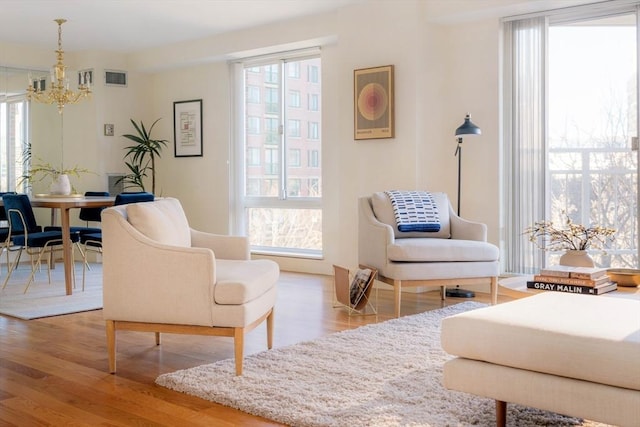 living area featuring hardwood / wood-style flooring and a notable chandelier