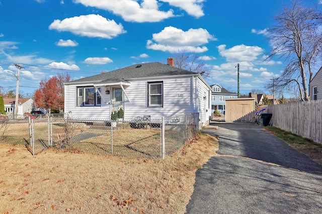 view of front of home featuring a front lawn and a shed