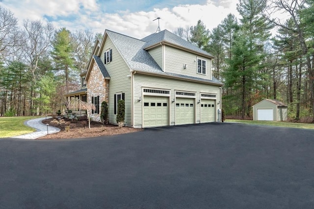 46 Mansfield Ave, Norton, MA 02766 - view of side of property featuring roof with shingles, driveway, and an attached garage