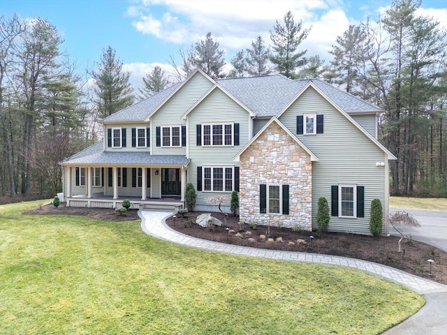 46 Mansfield Ave, Norton, MA 02766 - view of front facade with a front yard, stone siding, covered porch, and roof with shingles