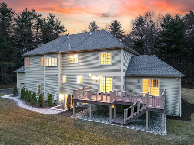 46 Mansfield Ave, Norton, MA 02766 - back of house at dusk featuring a deck, roof with shingles, stairs, and a lawn