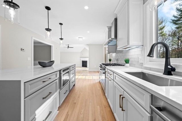 46 Mansfield Ave, Norton, MA 02766 - kitchen featuring tasteful backsplash, light wood-style flooring, a sink, appliances with stainless steel finishes, and hanging light fixtures