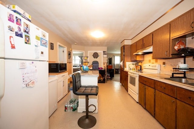 60 High Ridge Rd, Worcester, MA 01602 - kitchen featuring white appliances, under cabinet range hood, a sink, light countertops, and washer / dryer