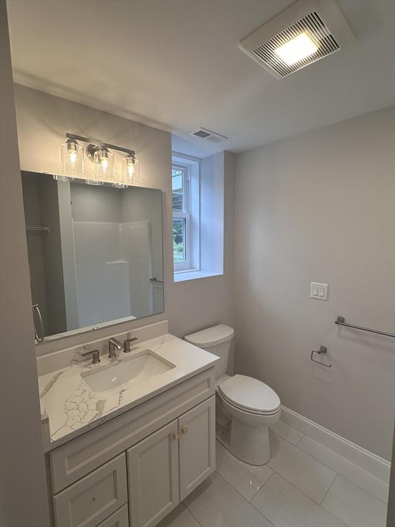 58 Dudley Rd, Billerica, MA 01821 - full bath with toilet, vanity, marble look tile flooring, and baseboards