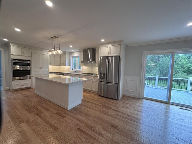58 Dudley Rd, Billerica, MA 01821 - kitchen with appliances with stainless steel finishes, wall chimney range hood, a sink, ornamental molding, and white cabinetry