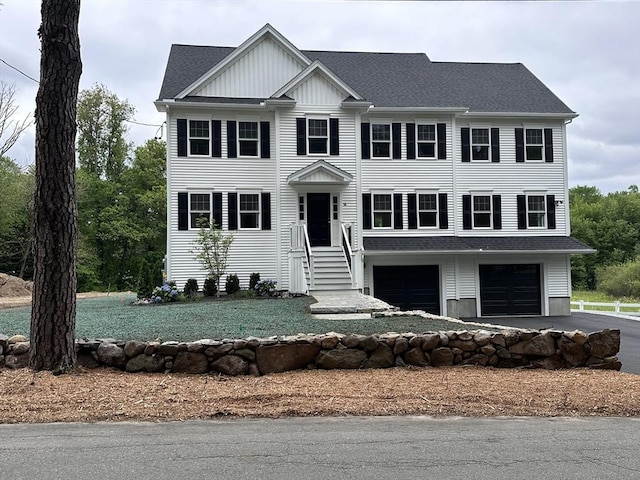 58 Dudley Rd, Billerica, MA 01821 - view of front facade with an attached garage, board and batten siding, driveway, and roof with shingles