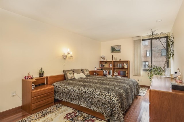 bedroom featuring wood-type flooring and baseboards