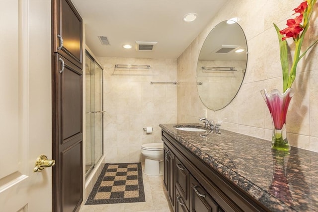 bathroom with visible vents, toilet, a stall shower, and tile walls